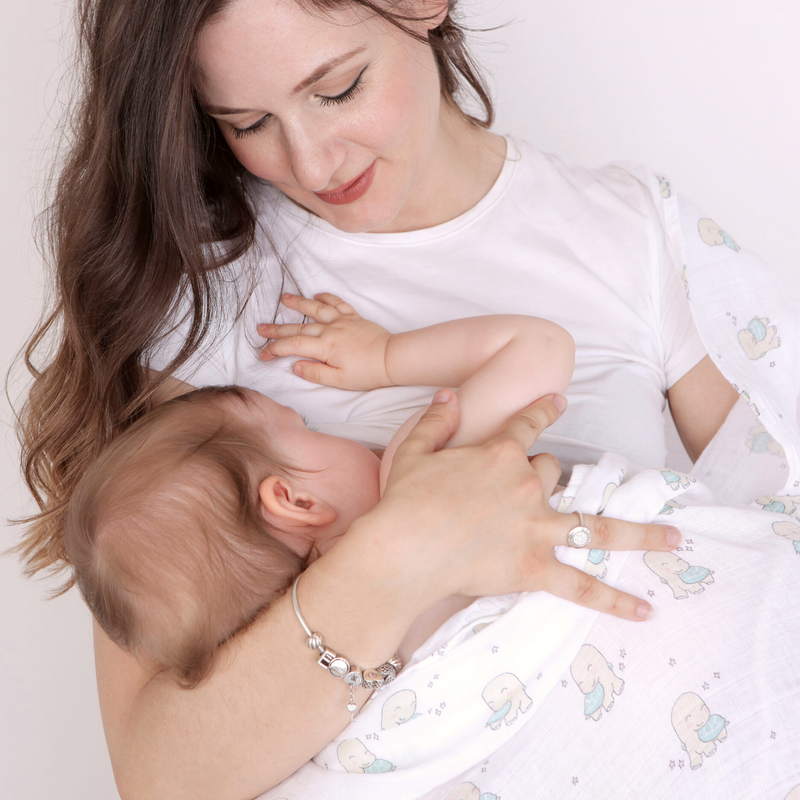 Mamma con bambina e la mussola durante allattamento. la mussola non fa sudare sotto la testa della piccola e ripara 